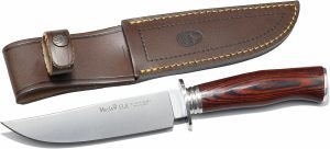 Cuchillo Muela (España). Hoja tipo bowie de acero inoxidable MoVa. Empuñadura en madera de coral, guarda, virola y pomo en acero inoxidable, funda de cuero para el cinto de color marrón.