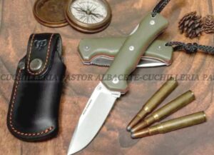 La Cudeman MT-4-384 es una navaja táctica, supervivencia y coleccionistas exigentes para los aventureros más exigentes. Su fiabilidad, robustez y precisión la convierten en una compañera imprescindible para actividades de bushcraft, caza, senderismo, supervivencia y outdoor. Con una hoja de 9,5 cm de longitud y un mango de 12 cm, la longitud total alcanza los 21,5 cm, ofreciendo un equilibrio perfecto entre maniobrabilidad y capacidad de corte. El grosor de 3 mm y el ancho de pala de 2,5 cm garantizan una excelente resistencia estructural, permitiendo realizar cortes limpios, precisos y duraderos incluso bajo gran presión. La hoja presenta un vaciado completo con acabado satinado, una punta Drop-Point versátil y un acero de altas prestaciones Böhler N690Co con una dureza de 60/61 HRc. Este acero premium ofrece una retención de filo sobresaliente, resistencia a la corrosión y facilidad de afilado, cualidades muy valoradas entre los expertos en supervivencia y montañismo.  la Cudeman MT-4-384 incorpora un sistema de bloqueo trasero (back lock) que evita cierres accidentales durante el uso. Mango en micarta negra con separador rojo no solo aporta un diseño moderno y distintivo El anclaje mediante tornillo allen inoxidable y casquillo interior roscado de latón refuerza su solidez y facilita el mantenimiento. La navaja se completa con una funda de cuero resistente, elegante y funcional, que permite transportarla de forma segura y cómoda. Con un peso aproximado de 170 g  logra el equilibrio ideal entre ligereza y robustez. Es la herramienta perfecta para quienes buscan una navaja de supervivencia fiable, versátil y fabricada con estándares profesionales. Especificaciones técnicas Cudeman MT-4 Característica Detalle Longitud de hoja 9,5 cm Longitud de mango 12 cm Longitud total 21,5 cm Grosor de hoja 3 mm Ancho de pala 2,5 cm Tipo de hoja Vaciado con acabado satinado Punta Drop-Point Acero Böhler N690Co Dureza del acero 60/61 HRc Sistema de cierre Bloqueo trasero (Back Lock) Anclaje del mango Tornillo allen inox / casquillo interior roscado de latón Mango Micarta negra con separadores en rojo Funda Cuero Peso de la pieza 170 g (aprox.) Peso de la funda 55 g (aprox.) La Cudeman MT-4 es una navaja de supervivencia y outdoor de alta gama, diseñada para ofrecer el máximo rendimiento en cualquier entorno.